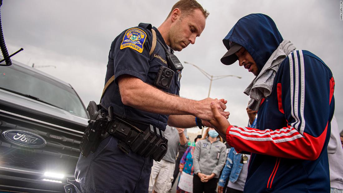 Police officers are joining protesters for prayers and hugs in several US cities